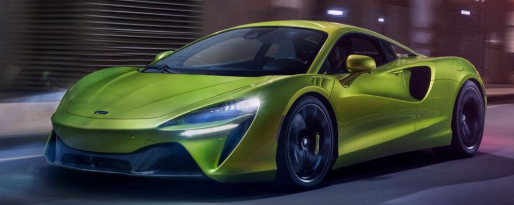Green 2022 McLaren Artura driving down highway